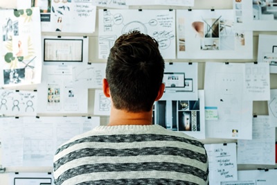 image of man standing in front of wall full of notes representing the planning process